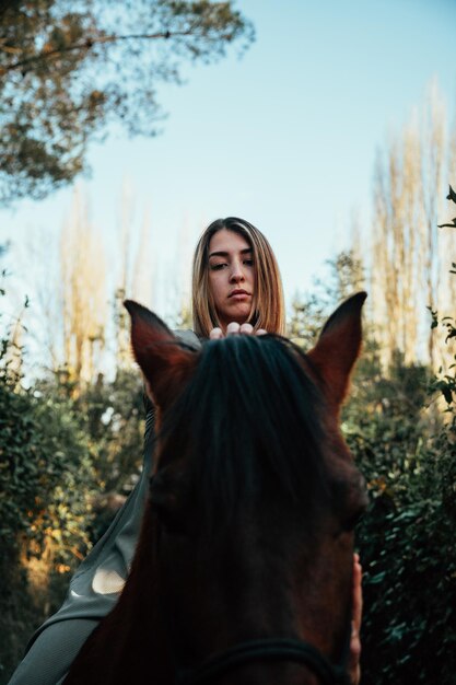 Foto donna con il cavallo nella foresta