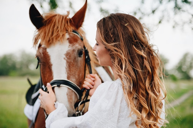 Foto donna con il cavallo in piedi sul campo