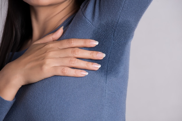 Woman with hyperhidrosis sweating on her clothes. Healthcare concept.