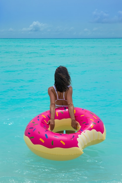 Женщина с надувным пончиком в море