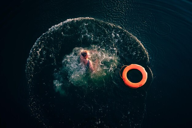 写真 浮気指輪をかぶった女性が海で泳いでいます