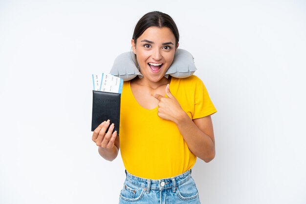 Woman with inflatable travel pillow over isolated background\
with surprise facial expression