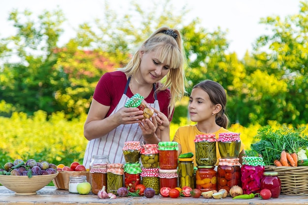 冬の母と娘の jar 保存野菜を持つ女性の選択と集中