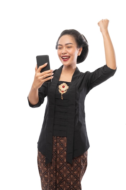 Woman with kebaya clothes happy looking at phone