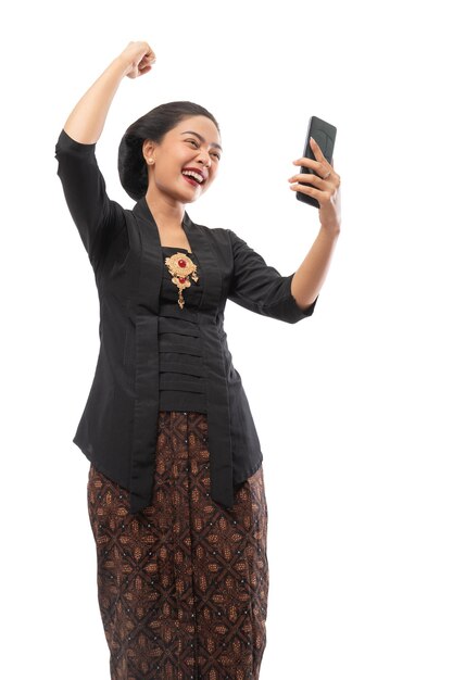 Woman with kebaya clothes happy looking at phone