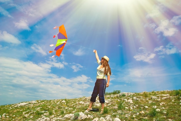 Woman with kite against the blue sky