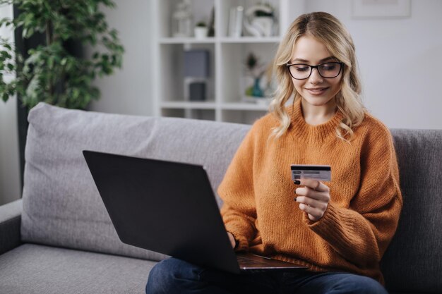 Женщина с ноутбуком и картой покупает онлайн