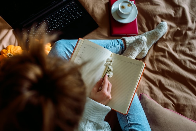 Photo woman with a laptop in her hands sitting on the bed.