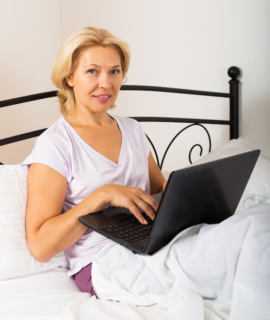 Woman with laptop laying