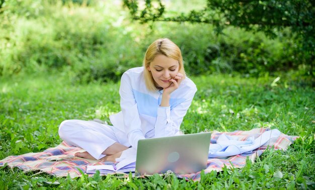 Woman with laptop or notebook sit on rug green grass meadow Business lady freelancer work outdoors Online business ideas concept Business picnic concept Steps to start freelancing business