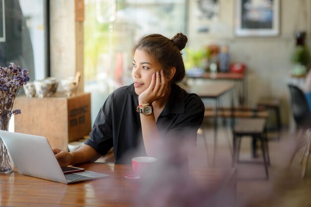 写真 レストランのテーブルに座っているラップトップの女性