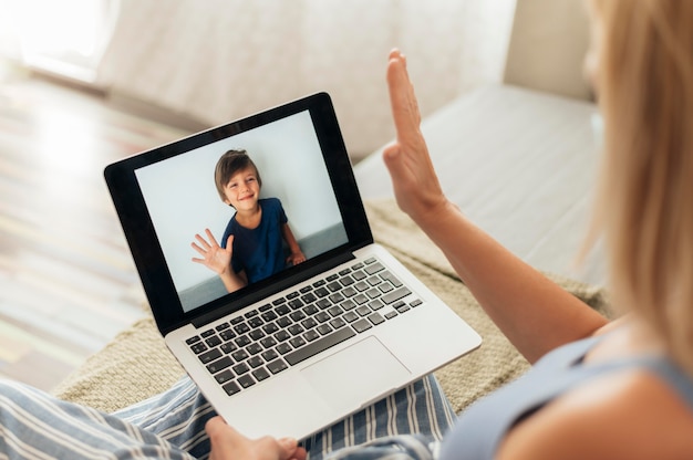 Woman with laptop video calling nephew during quarantine