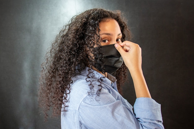 Foto donna con camicia azzurra e maschera nera