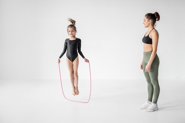 Donna con una bambina sull'allenamento di ginnastica ritmica