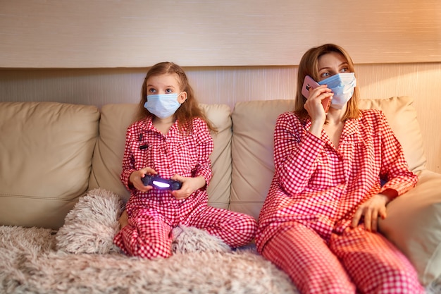 Woman with little kid at home wearing face mask