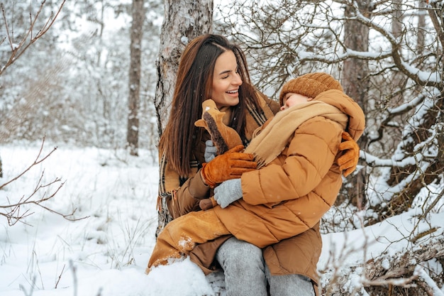 Woman with a little son on a winter hike in the snowy forest