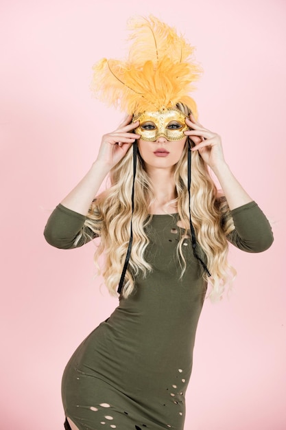 Woman with long blond hair in carnival mask.