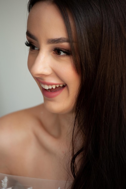 A woman with long brown hair smiles at the camera