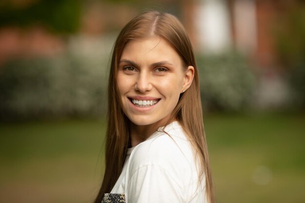 A woman with long brown hair smiles at the camera.