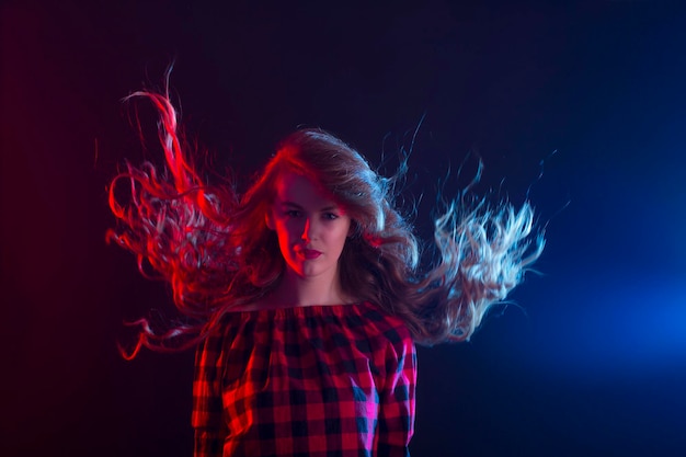 Woman with long curly hair in motion at studio