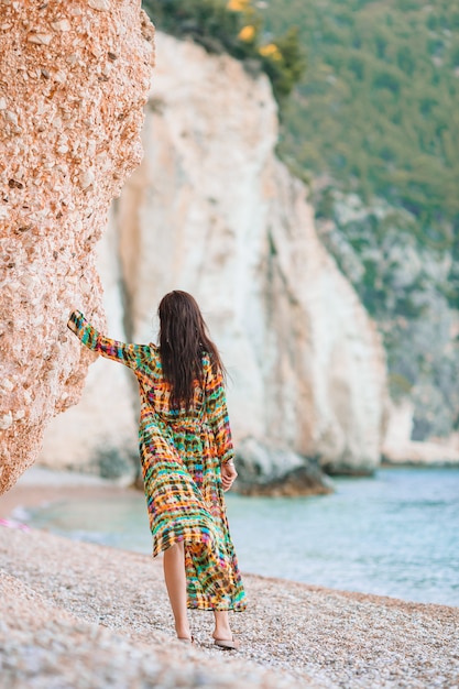 Woman with long dress looking at the sea