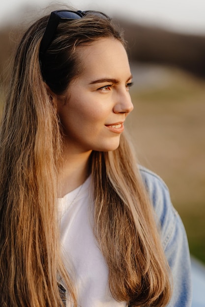 A woman with long hair and a blue shirt is looking to the left.