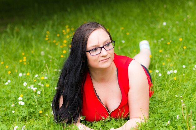 Foto donna con i capelli lunghi sdraiata sul campo erboso