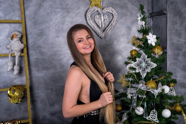 Woman with long hair posing with fir-tree