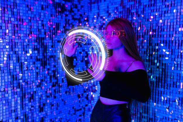 A woman with long hair in virtual reality glasses presses the start button Augmented reality game future technology AI concept Holographic interface for displaying data