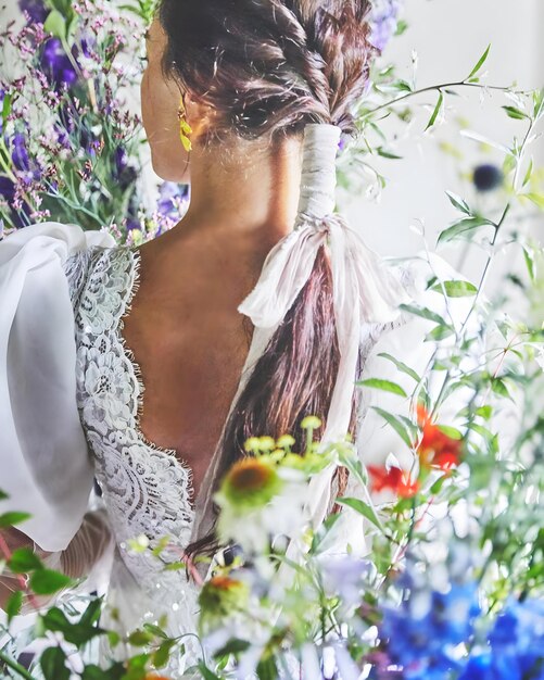 Photo a woman with long hair and a white shawl with flowers in the background