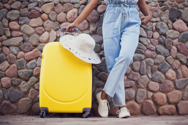 Woman with luggage and hat outdoor. Travel, holiday and lifestyle concept