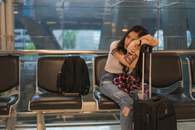 Foto donna con i bagagli seduta nell'area di partenza dell'aeroporto