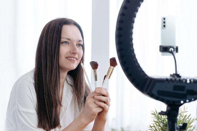 Woman with makeup brushes sitting at the table