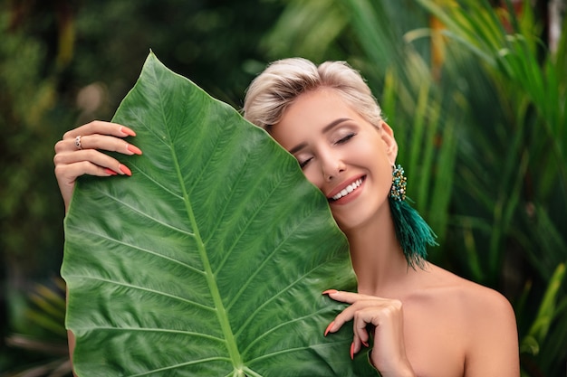 Woman with makeup posing with leaves