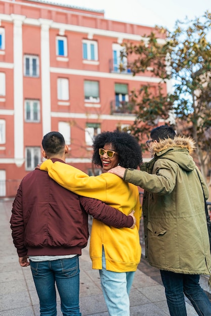 Foto donna con amici maschi che camminano per strada