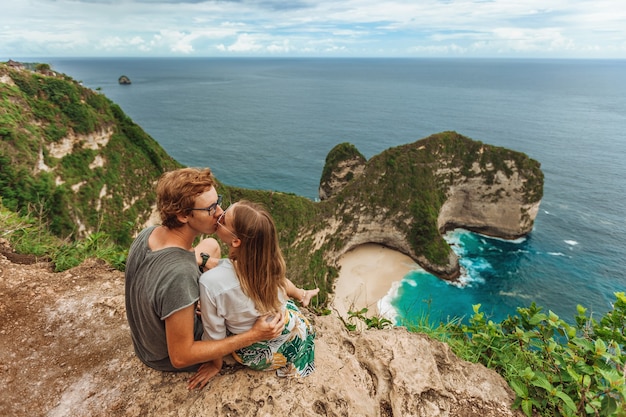 Donna con un uomo a kelingking beach a nusa penida bali indonesia