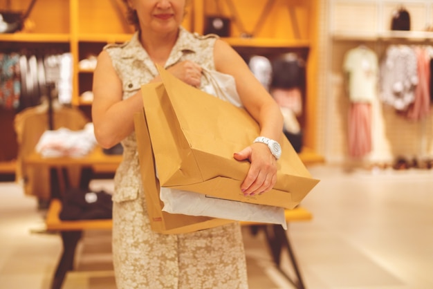 Woman with many paper bags in the clothes store