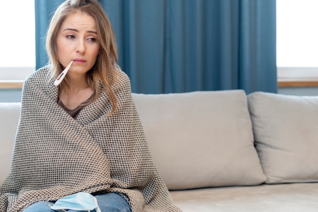 Photo woman with mask in quarantine sitting on a couch