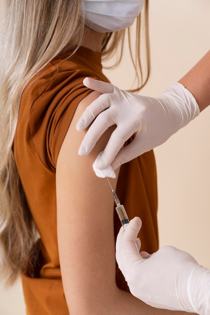 Photo woman with medical mask receiving a vaccine