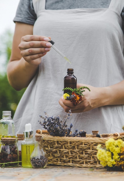 Foto donna con erbe medicinali e tinture messa a fuoco selettiva