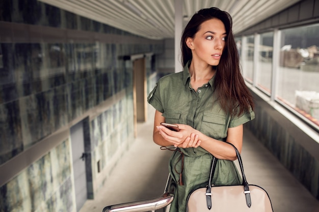 Foto donna con un cellulare e una borsa