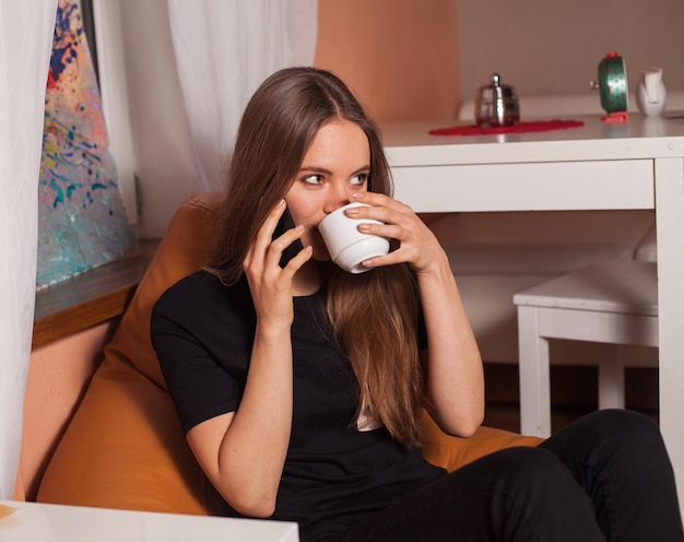 Donna con telefono cellulare e tazza di caffè