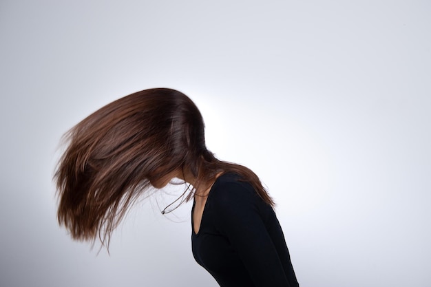 A woman with modern and fashion hairstyle plays with her long hairs