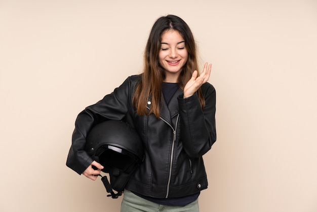 Woman with a motorcycle helmet on beige wall unhappy and frustrated with something