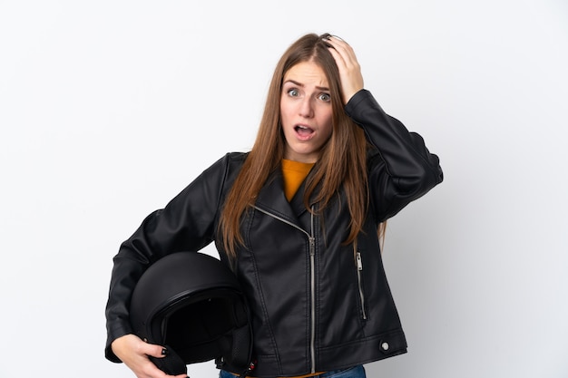 孤立した壁の上のオートバイのヘルメットを持つ女性