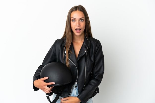 Woman with a motorcycle helmet over isolated white background with surprise facial expression