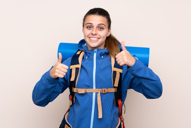 Woman with mountaineer backpack over isolated wall