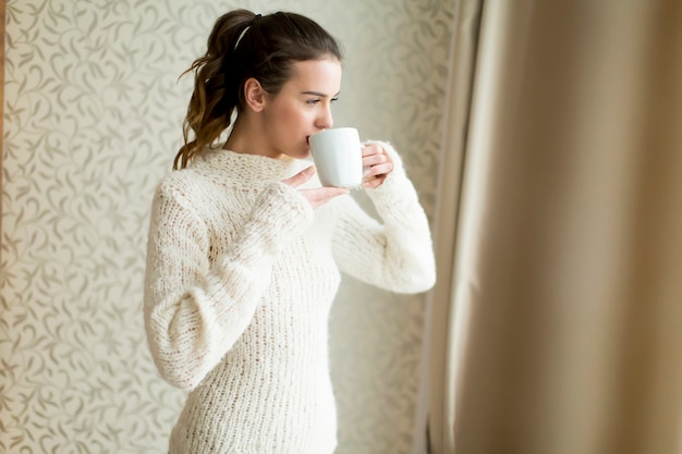 Woman with mug by window