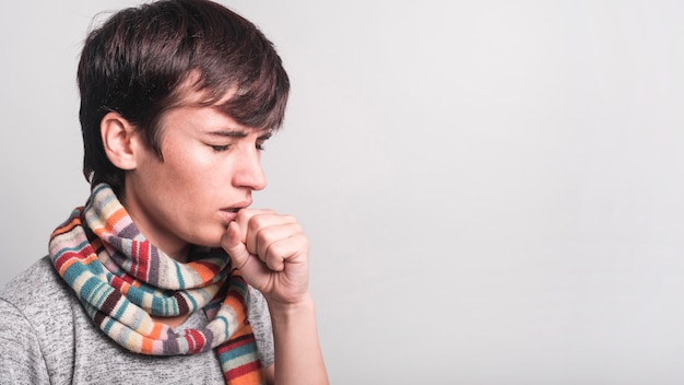 Photo woman with multicolored scarf around her neck coughing against gray backdrop