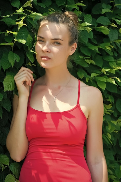Woman with natural makeup in prague czech republic on sunny day Sensual woman on green fence Girl with young look and beauty Fashion model in pink dress Summer vacation and wanderlust concept